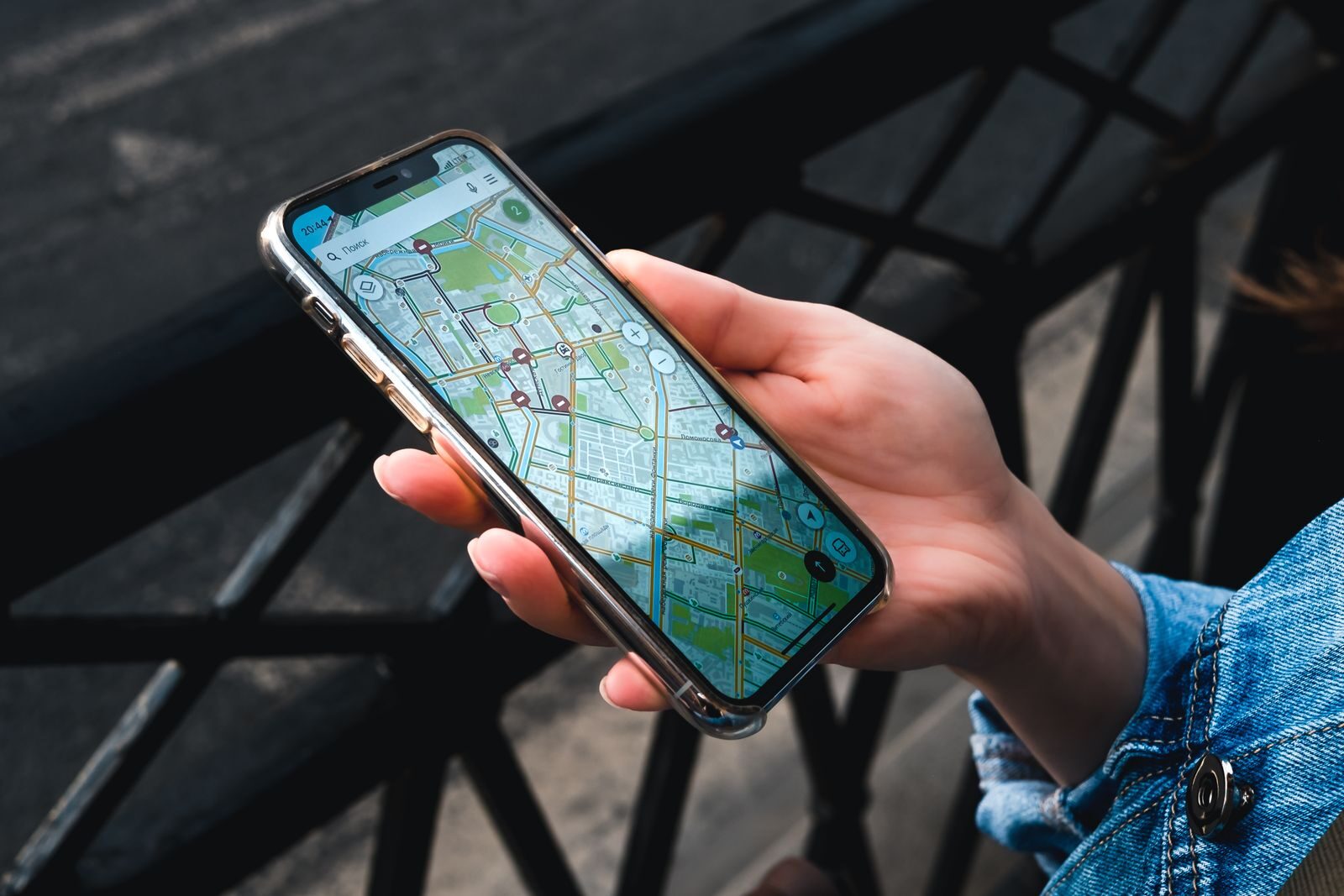 Hand holding a smartphone showing a map app outdoors