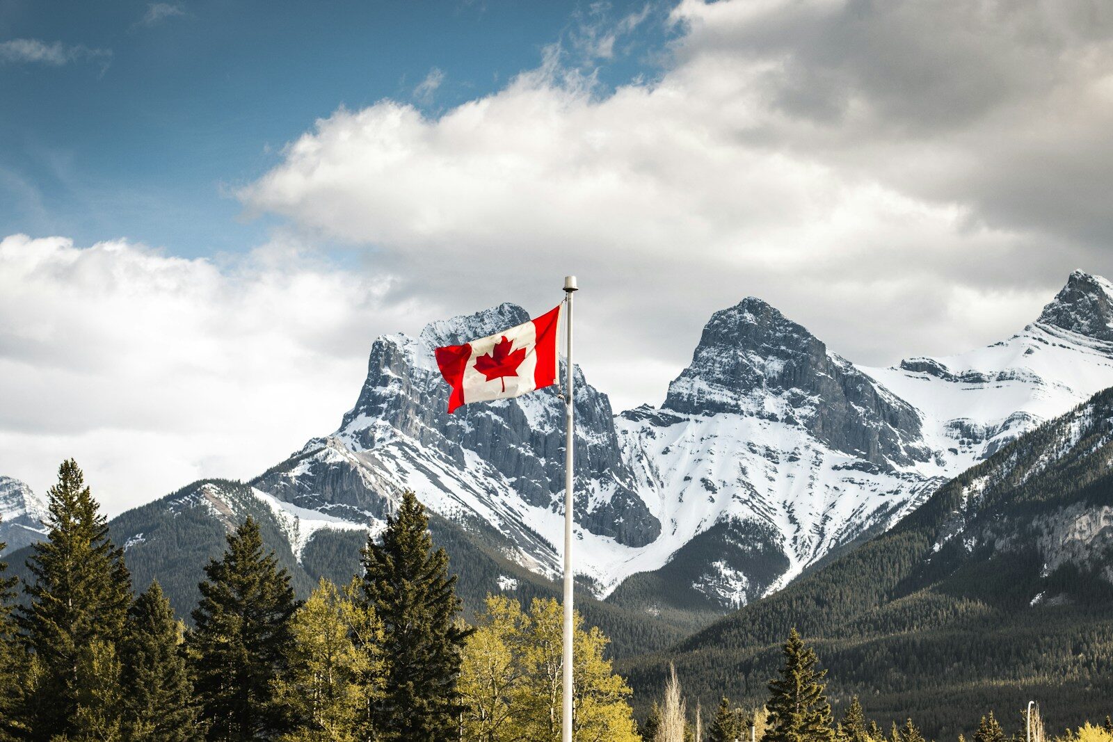 Canadian flag in front of the Three Sisters mountains in Canmore, Alberta